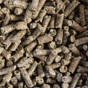 Bruns granulés compacts, possibles aliments animaux ou biomasse, disposés en tas.