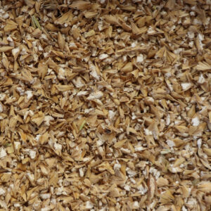 Tas de grains concassés avec particules marron clair et blanches.