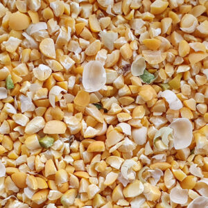 Mélange de grains de maïs concassés jaunes et blancs, fragments de tailles variées.