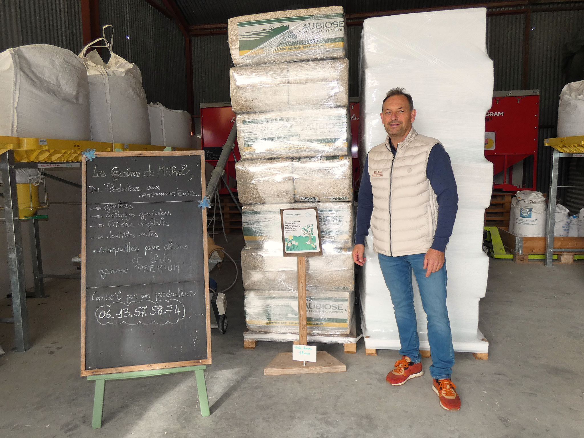 Un homme dans un entrepôt avec des sacs sur des étagères métalliques en arrière-plan.